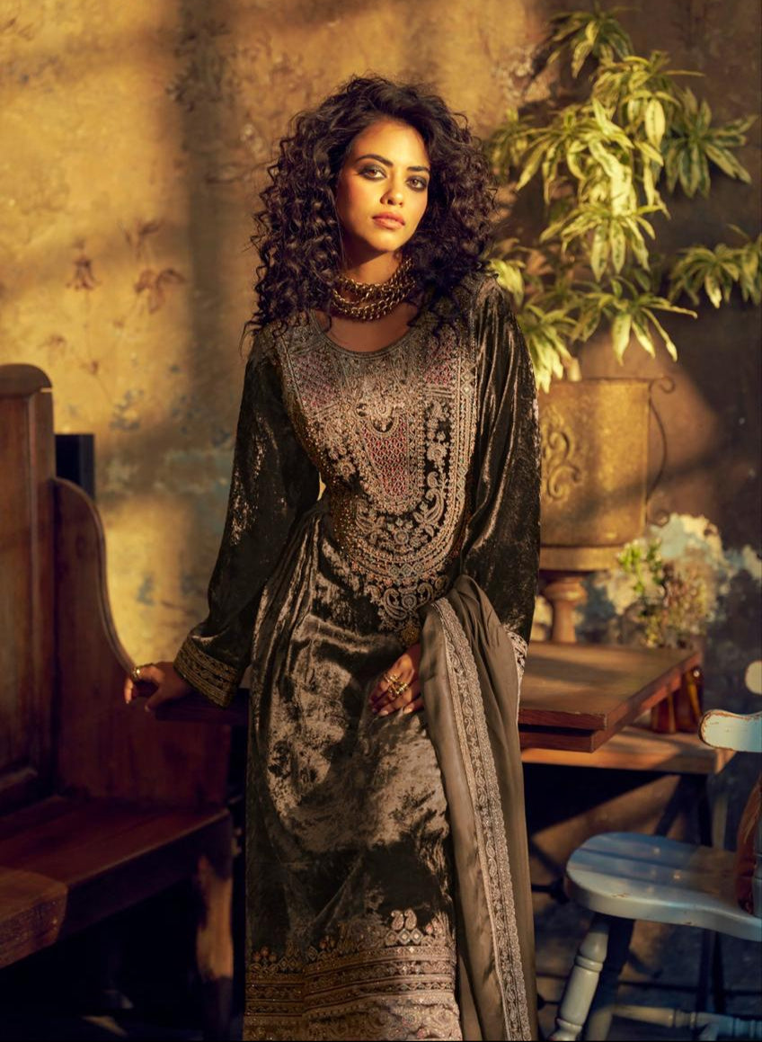 Woman in a patterned dress standing in an indoor setting with decorative elements.